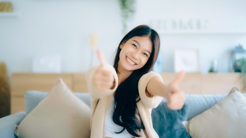 happy woman smiling and giving thumbs up to camera