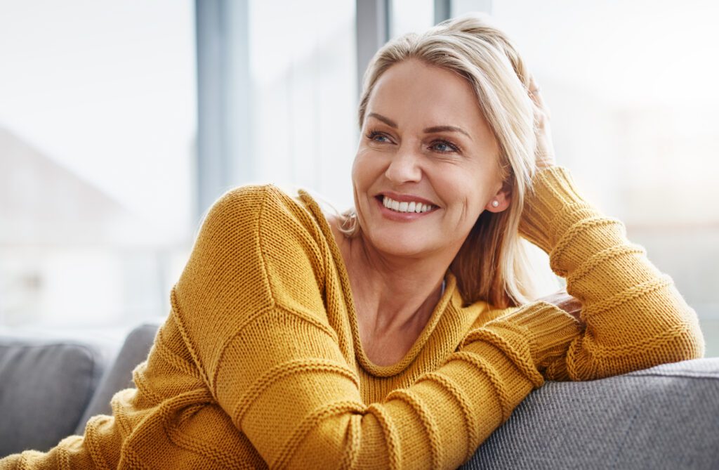 Woman smiling and sitting on couch